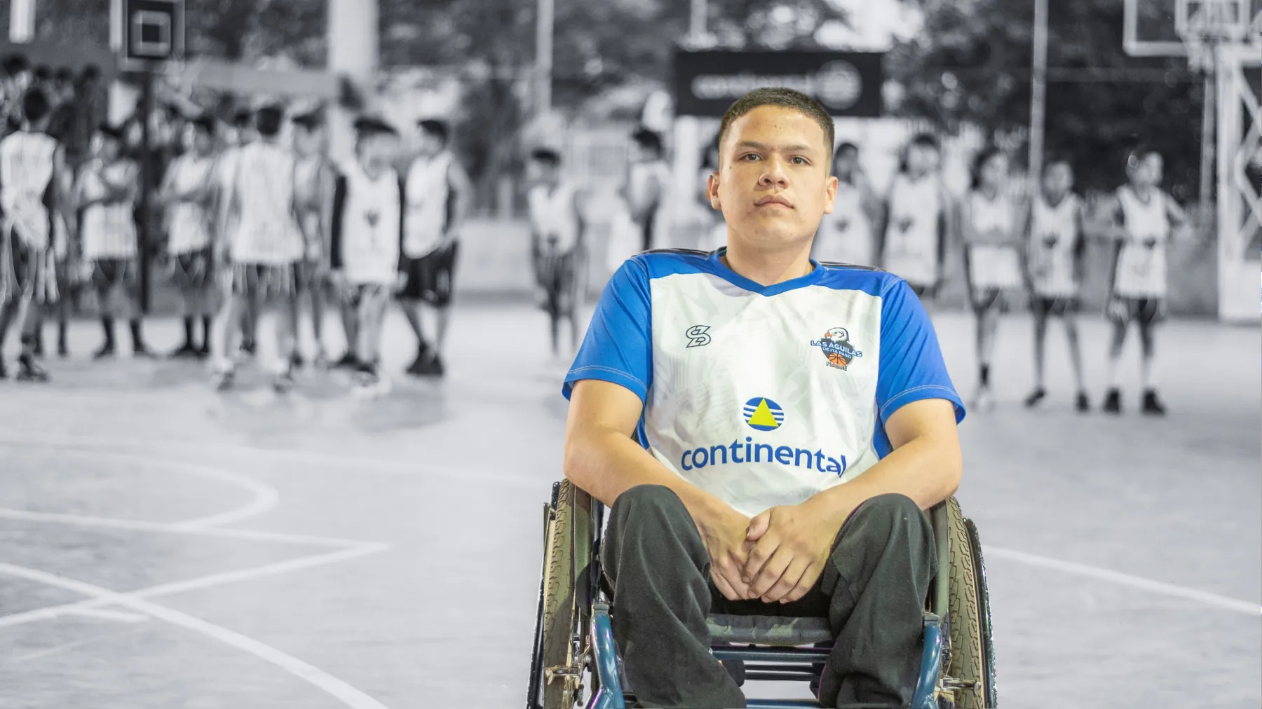 Un jugador del PRODE en silla de ruedas, en el centro de la cancha, con el resto del equipo al fondo.